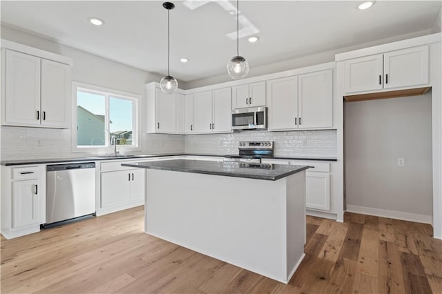 kitchen with decorative light fixtures, light wood-type flooring, white cabinetry, and stainless steel appliances