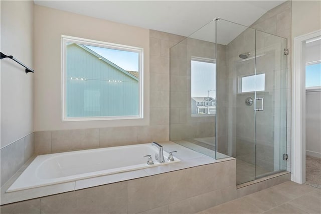 bathroom with tile patterned floors, vaulted ceiling, and shower with separate bathtub