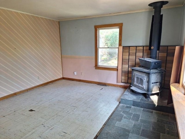 unfurnished living room featuring a wood stove and ornamental molding