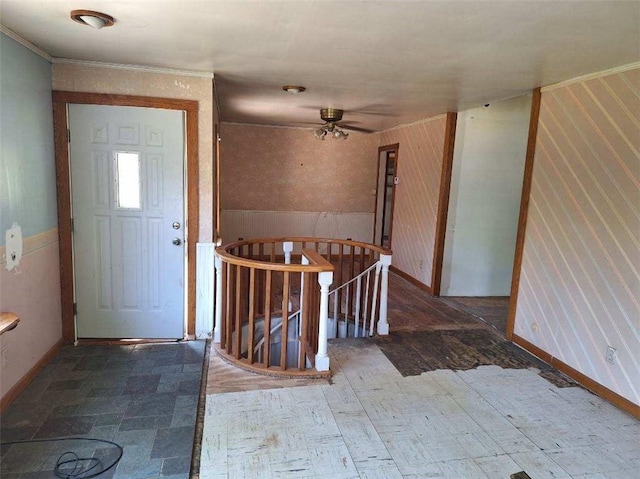 entrance foyer featuring ceiling fan and wood walls