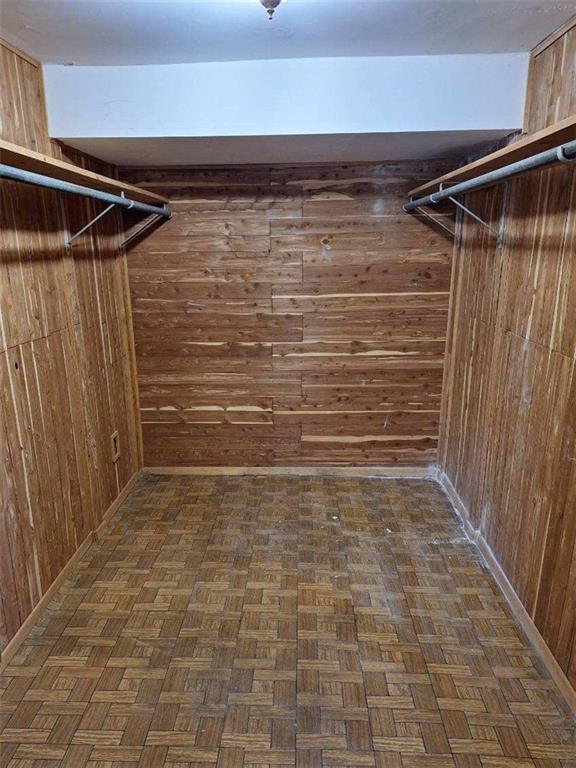 walk in closet featuring dark parquet flooring