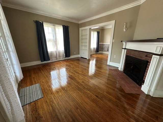 unfurnished living room featuring wood finished floors, crown molding, a fireplace, and baseboards