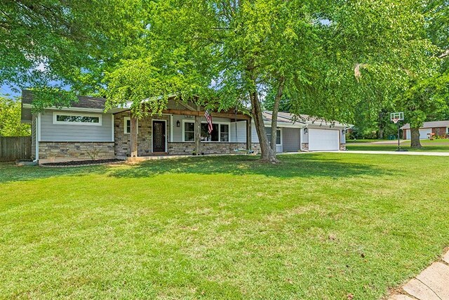 ranch-style house with a garage and a front lawn