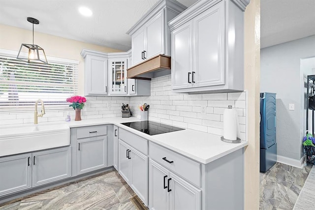 kitchen featuring light tile patterned flooring, backsplash, hanging light fixtures, and black electric cooktop