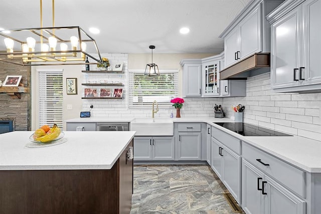 kitchen featuring backsplash, sink, light tile patterned floors, and pendant lighting