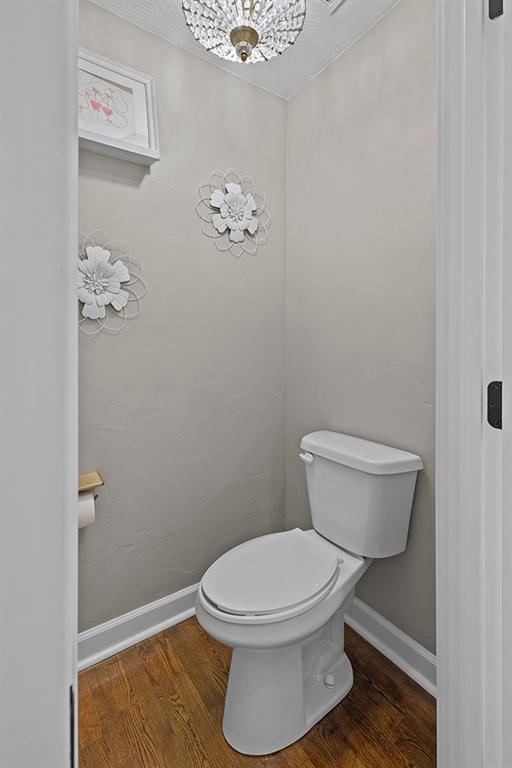 bathroom with toilet and hardwood / wood-style floors