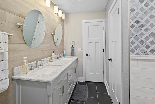 bathroom with wood walls, dual vanity, and tile patterned floors