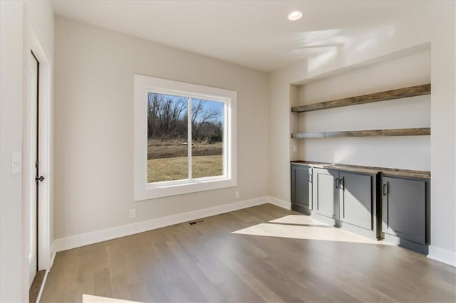 interior space featuring visible vents, recessed lighting, baseboards, and wood finished floors