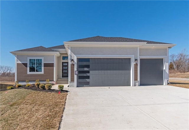 view of front of property with stucco siding, concrete driveway, a garage, and roof with shingles