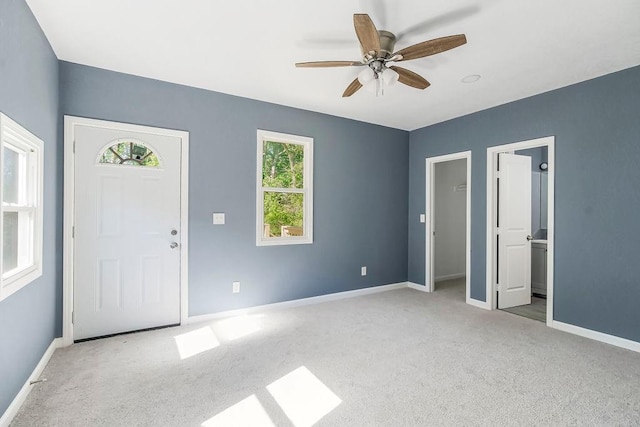 carpeted entryway with ceiling fan