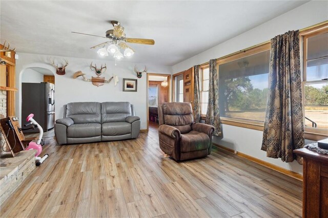 living room with light wood-type flooring and ceiling fan