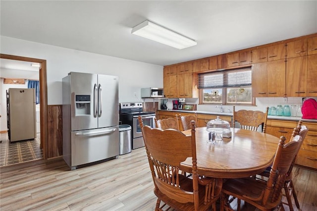 kitchen with appliances with stainless steel finishes and light hardwood / wood-style floors