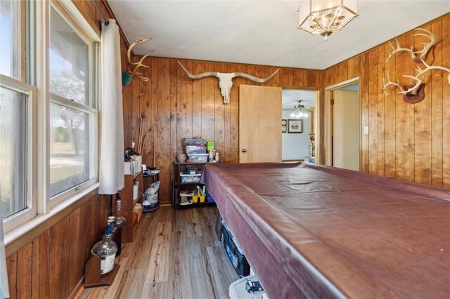 rec room with wood-type flooring, pool table, wooden walls, and ceiling fan