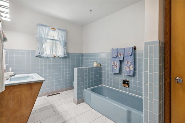 bathroom featuring tile walls, a bath, vanity, and tile patterned floors