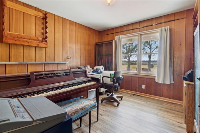 office with light wood-type flooring, wood walls, and baseboards