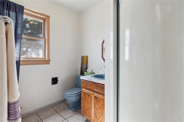 bathroom with tile patterned floors, vanity, toilet, and a healthy amount of sunlight