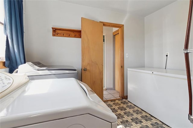 laundry room with laundry area, washing machine and clothes dryer, and tile patterned floors