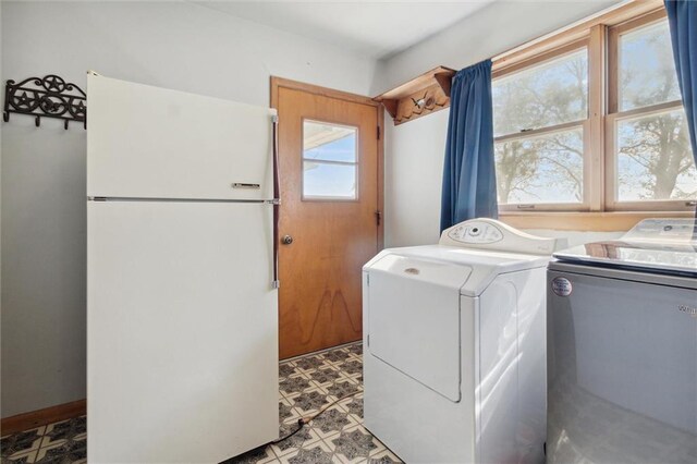 clothes washing area featuring washing machine and dryer and light tile patterned flooring