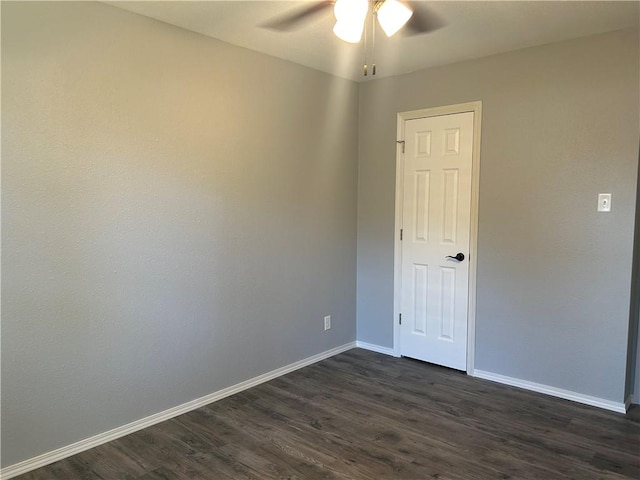 spare room featuring dark wood-type flooring and ceiling fan