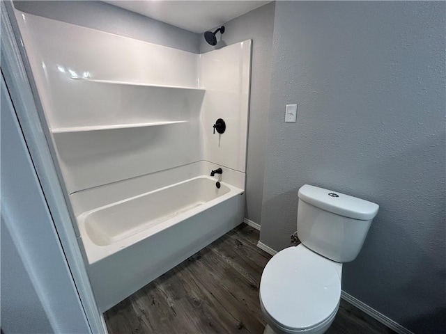 bathroom featuring toilet, hardwood / wood-style flooring, and shower / washtub combination