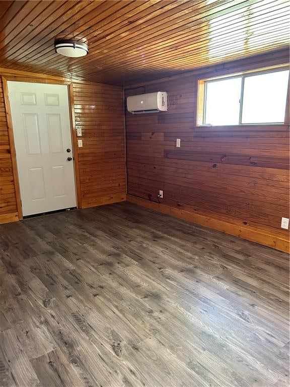 unfurnished room featuring wooden ceiling, dark wood-type flooring, a wall mounted air conditioner, and wooden walls