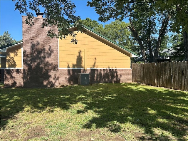 view of side of home featuring a yard and cooling unit