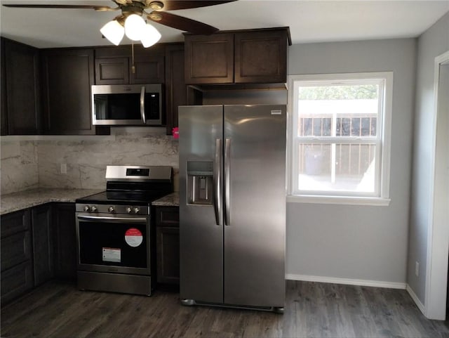 kitchen featuring ceiling fan, light stone counters, appliances with stainless steel finishes, and dark hardwood / wood-style flooring