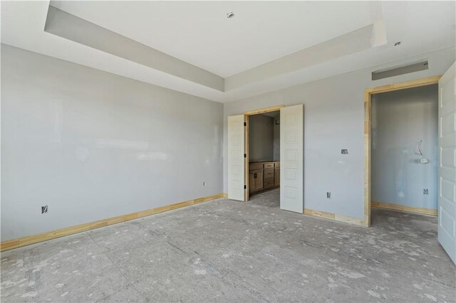 unfurnished bedroom with a raised ceiling