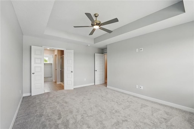 780 Creekmoor Dr, Raymore, MO 64083 - unfurnished bedroom with carpet flooring, a raised ceiling, baseboards, and ensuite bathroom
