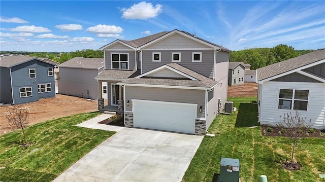 780 Creekmoor Dr, Raymore, MO 64083 - view of front of property featuring central AC unit, driveway, a front lawn, stone siding, and roof with shingles