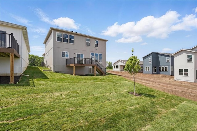 780 Creekmoor Dr, Raymore, MO 64083 - back of property featuring stairs, central AC unit, a lawn, and a deck