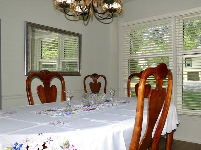 dining area featuring hardwood / wood-style floors and an inviting chandelier