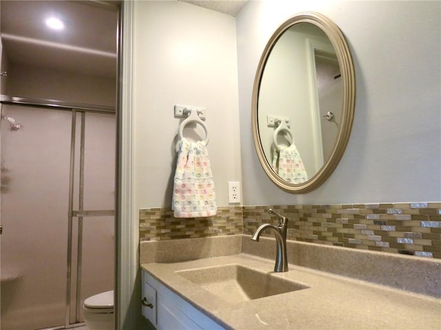 bathroom with backsplash, toilet, and vanity