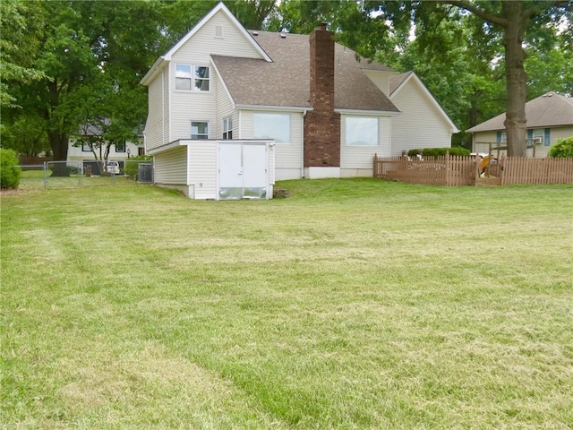 rear view of house with a yard and a storage shed