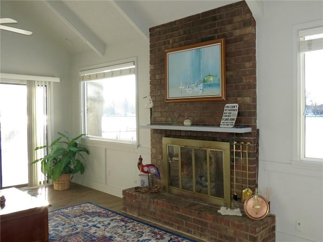 sitting room featuring a fireplace, hardwood / wood-style floors, and vaulted ceiling with beams