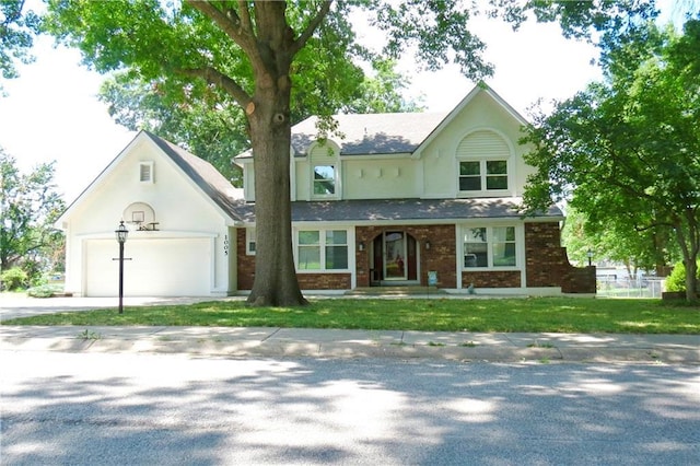 1005 Johnston Dr, Raymore, MO 64083 - view of front of house featuring driveway, brick siding, a front lawn, an attached garage, and stucco siding