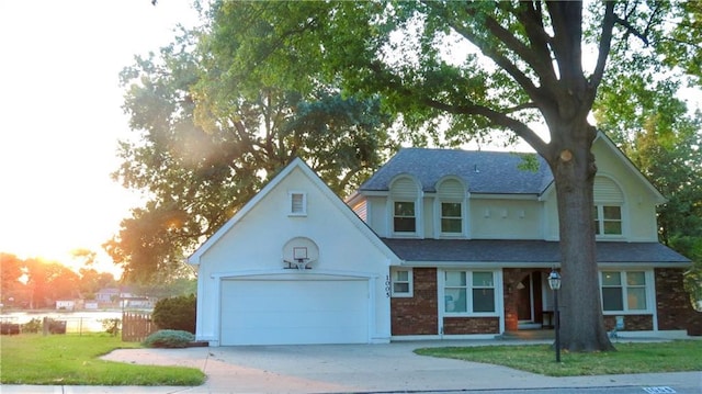 1005 Johnston Dr, Raymore, MO 64083 - view of front of home featuring concrete driveway, brick siding, a garage, roof with shingles, and stucco siding