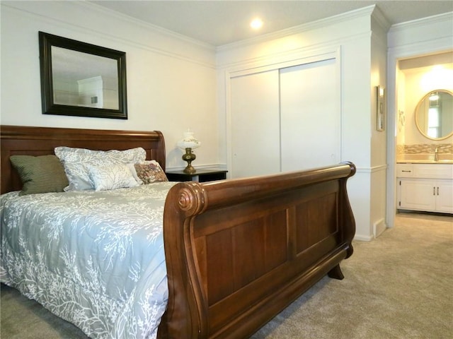1005 Johnston Dr, Raymore, MO 64083 - bedroom with light colored carpet, ornamental molding, a closet, a sink, and connected bathroom