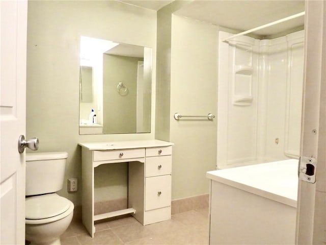 1005 Johnston Dr, Raymore, MO 64083 - bathroom featuring vanity, toilet, a shower, tile patterned floors, and baseboards