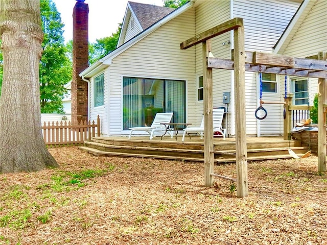 1005 Johnston Dr, Raymore, MO 64083 - back of property with a deck, roof with shingles, a chimney, and a pergola