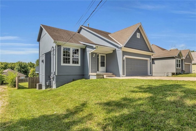 view of front of home featuring a front lawn, a garage, and cooling unit