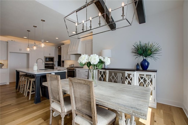 dining area with light hardwood / wood-style floors and sink