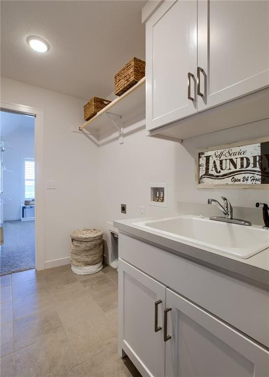 clothes washing area featuring sink, cabinets, hookup for a washing machine, and hookup for an electric dryer