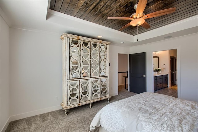 carpeted bedroom featuring a tray ceiling, ornamental molding, wooden ceiling, and ceiling fan