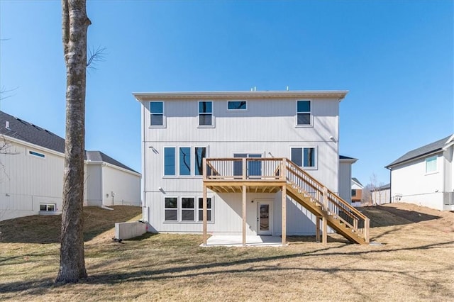 rear view of house with a yard, stairs, and a wooden deck