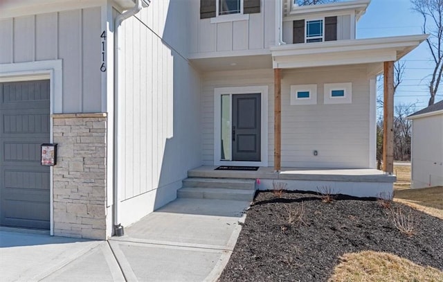 doorway to property with board and batten siding and a garage