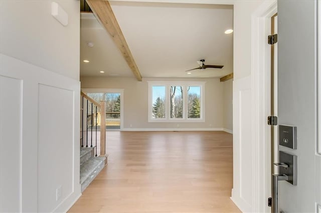 unfurnished living room with light wood finished floors, beamed ceiling, stairway, and recessed lighting