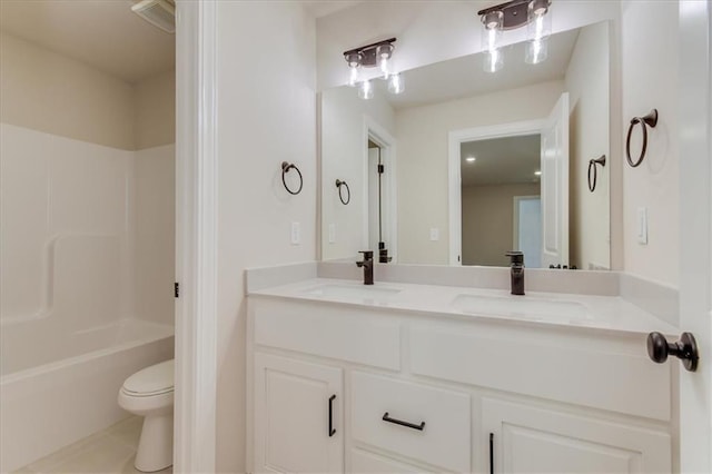 bathroom with visible vents, double vanity, a sink, and toilet