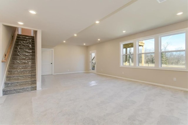 unfurnished living room with baseboards, stairway, and recessed lighting