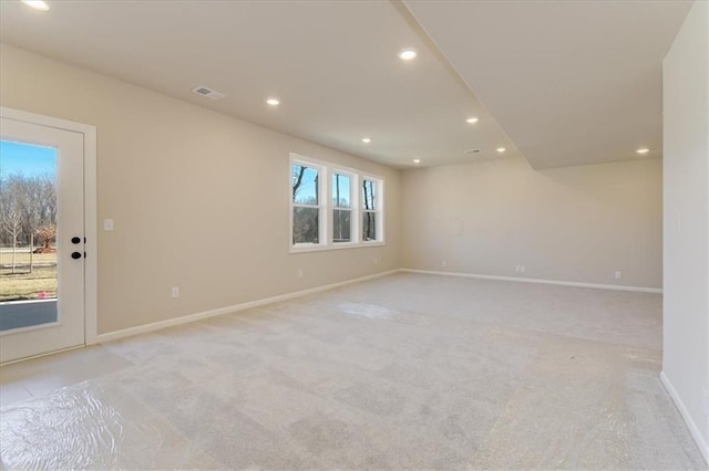 empty room with baseboards, light carpet, visible vents, and recessed lighting